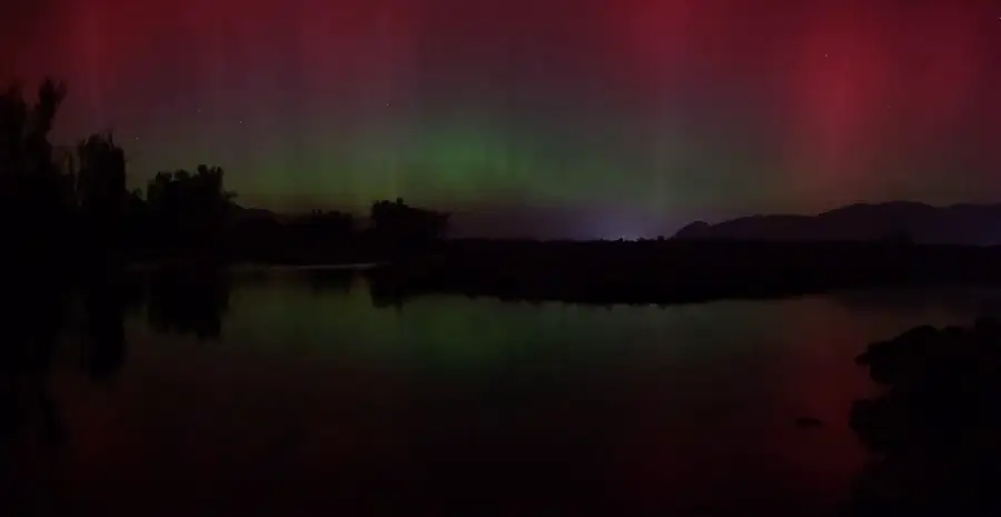 Aurora over a still lake at night