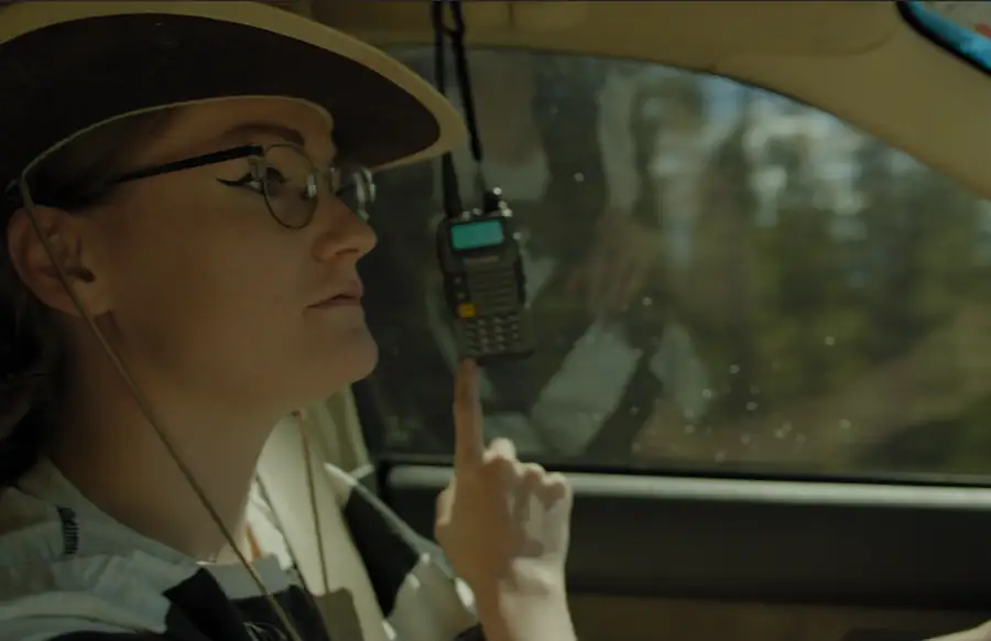 Park ranger in a vehicle holding a radio