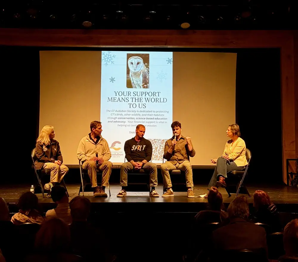 Panel on stage beneath an Audubon Society slide